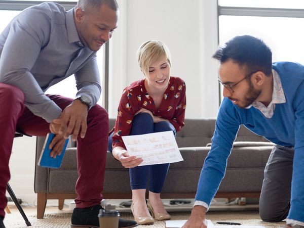 Three colleagues collaborating on a project in a casual office setting.