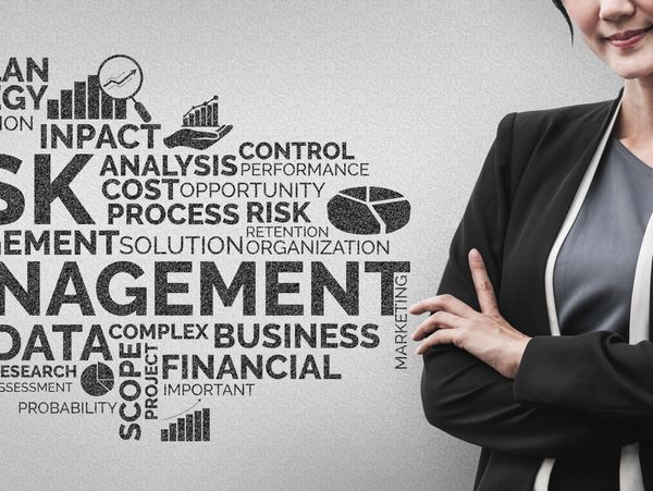 Businesswoman standing confidently with risk management word cloud.