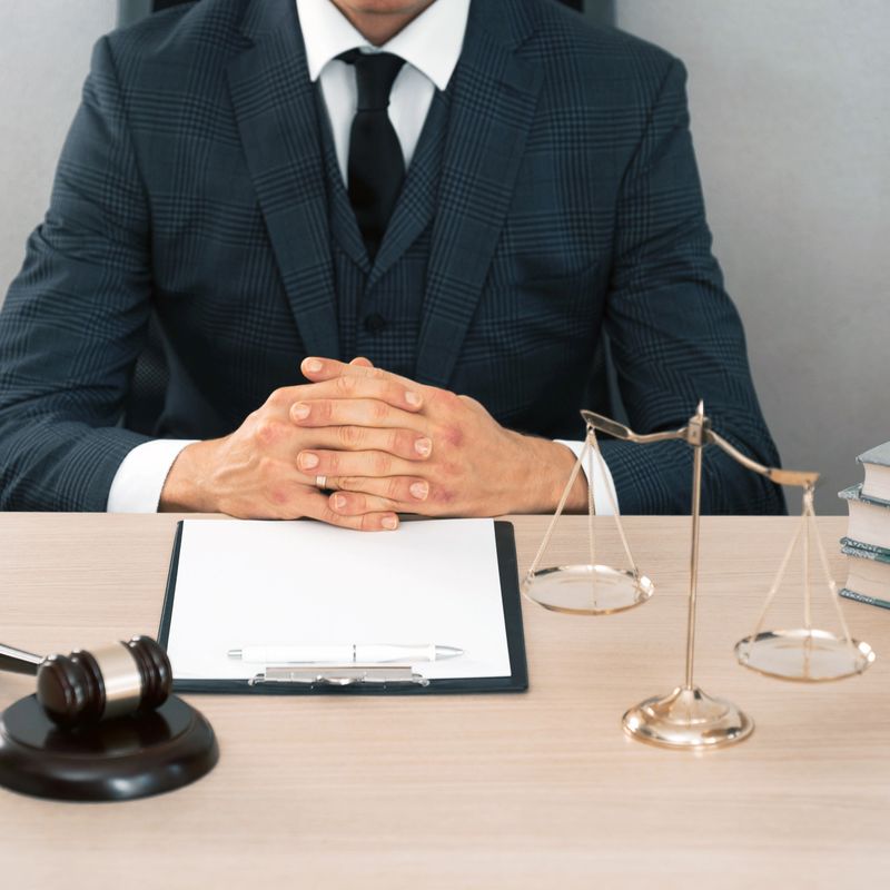 Law and Legal services concept. Male lawyer or judge working with contract papers, Law books and wooden gavel on table in courtroom