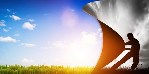 A person pulling back a dark sky to reveal a bright, sunny day.