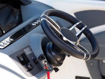 Close-up of a modern boat steering wheel and control panel.