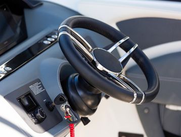 Close-up of a modern boat steering wheel and control panel.