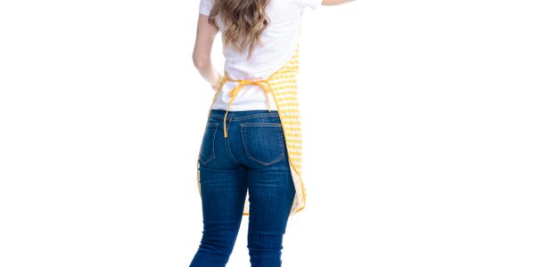 Woman wearing a yellow apron and blue jeans, facing away.