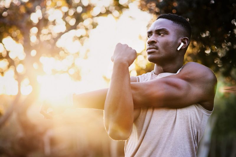 Shot of a young man stretching before a run outdoors