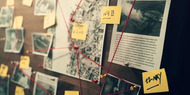 Investigation board with photos, maps, and notes connected by red string.