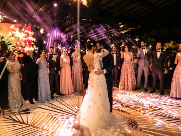 Sposi ballano circondati da invitati con stelline scintillanti.