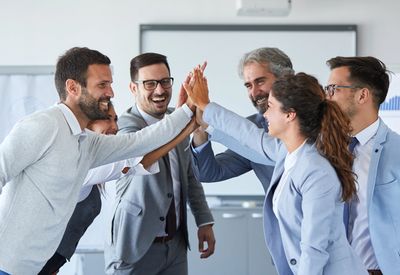 Toplantı sonunda başarılarını kutlayan insanlar