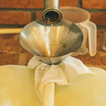 Using a funnel to pour liquid into a container wrapped with cloth.