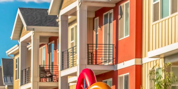 Colorful playground equipment in front of modern residential buildings.