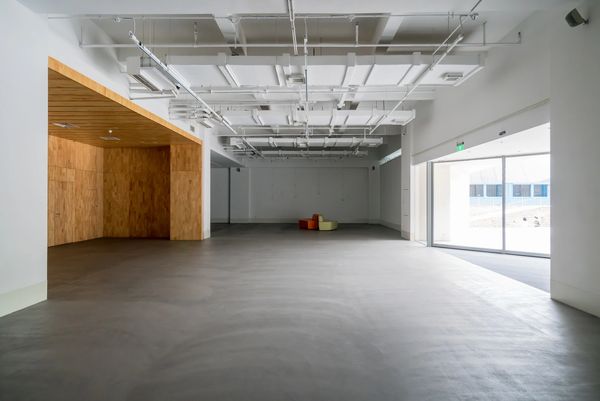 Empty spacious room with a wooden alcove and large glass sliding doors.