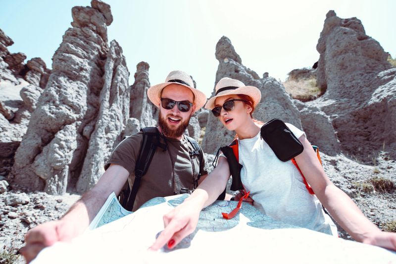 Male And Female Finding Their Location On A Map
