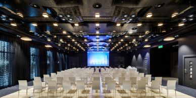 Modern conference room with chairs and screen.