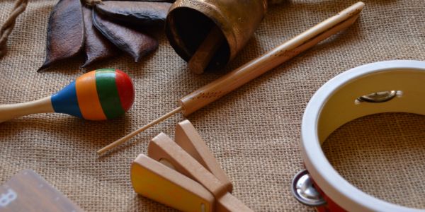 Various traditional musical instruments on a burlap surface.
