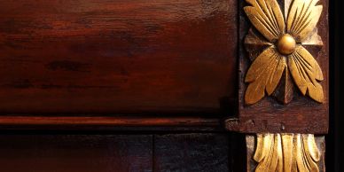 Intricate wooden carving with gold floral design.