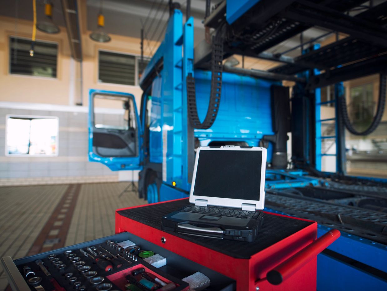 Laptop on a tool cart in a truck repair workshop.