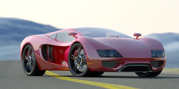 Sleek red sports car parked on an open road with mountains in the background.