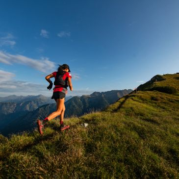 Woman trail running on mountain ridge.