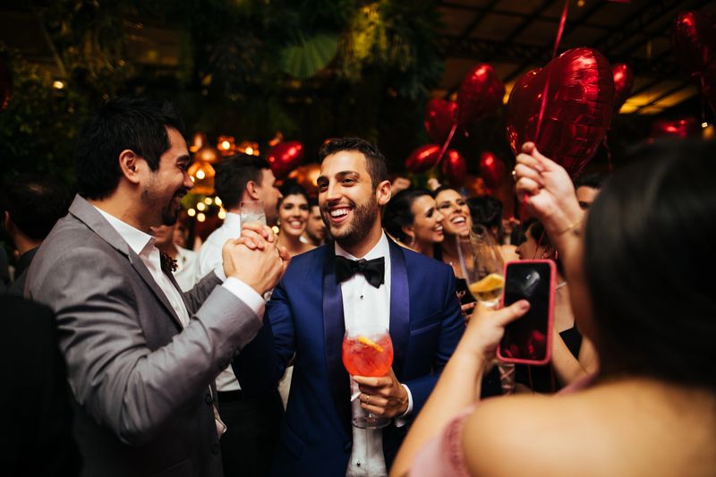 Groom and wedding guests laughing during party
