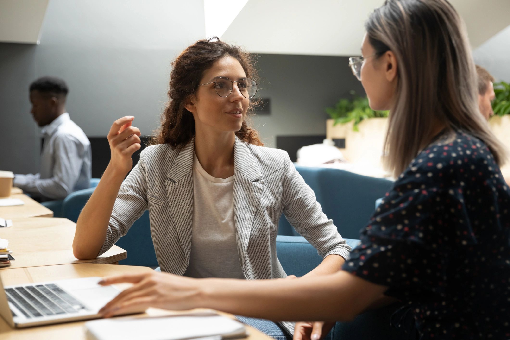 Two women having a conversation in a modern office.