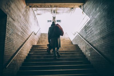 Person walking up a dimly lit stairway.