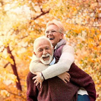 Pareja mayor feliz disfrutando de otoño.