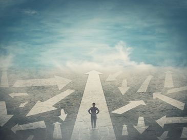 Person standing on a clear path amid many confusing arrows.