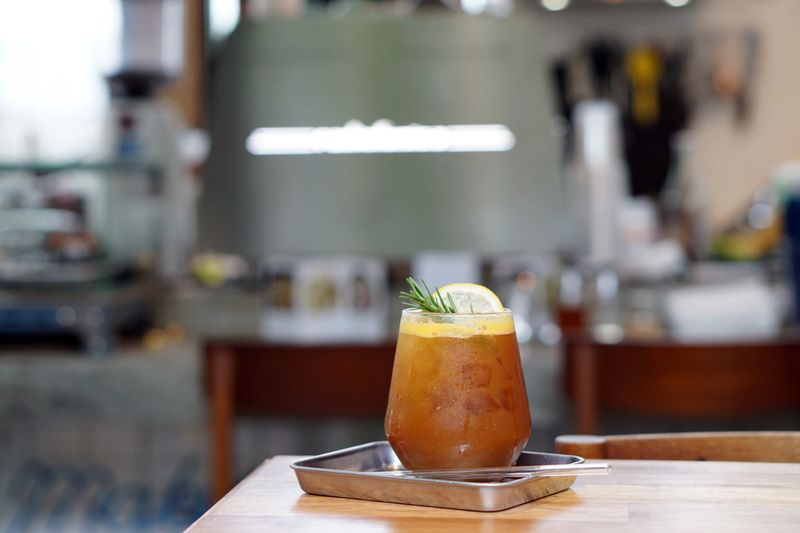 Iced coffee with orange - A glass of espresso shot mixed with orange juice and craft soda on blurred background, Barista making coffee cocktail, Perfect drink for summer time.
