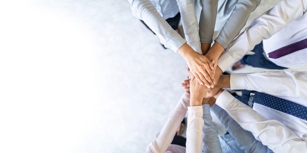 Equipo de trabajo apoyando sus manos