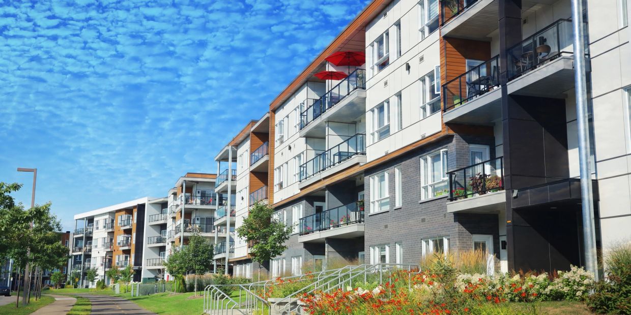 Modern apartment buildings under a blue sky.