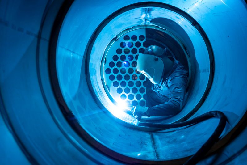 Welder man welding a multitubular heat exchanger in boilermaking industry