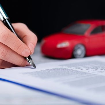 Signing car title or DMV paperwork with red vehicle in background – notary services NC