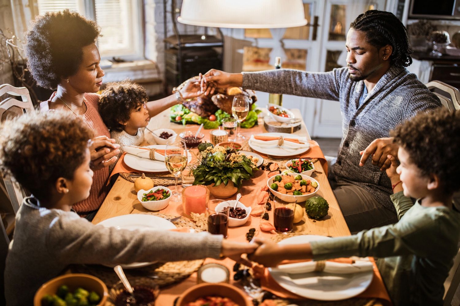 A family praying together at the dinner table