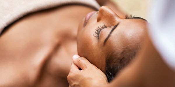Person receiving a head massage with closed eyes.
