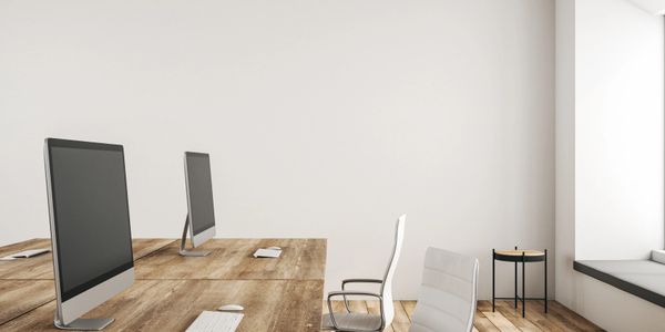 Minimalist office space with wooden desks and modern computers.