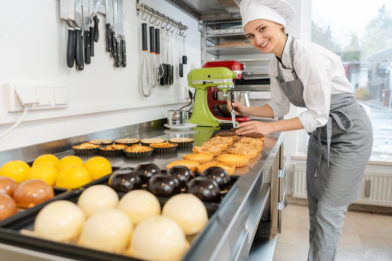 Confectioner working on lots of different sweets and desserts in her shop