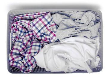Laundry basket filled with mixed clothes.