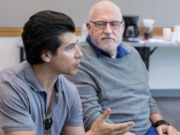 Two men engaged in a discussion indoors.
