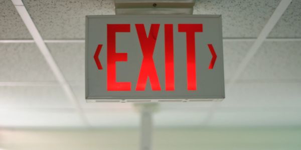 Lit red exit sign on ceiling.