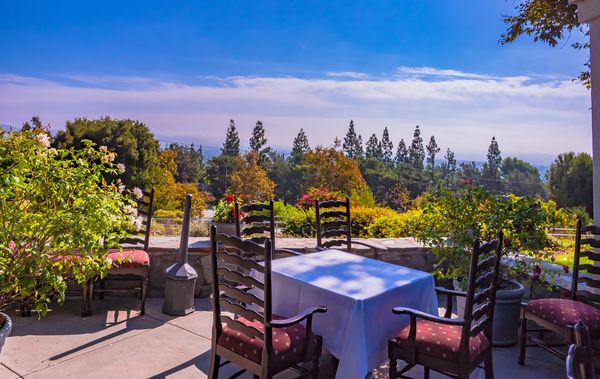 Outdoor dining table with chairs under clear blue sky.