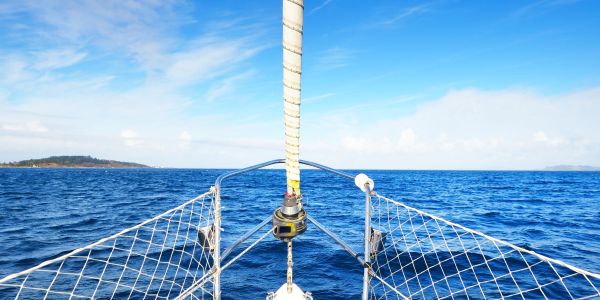 View from a sailboat at sea on a sunny day.