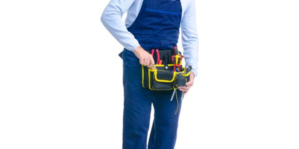 Person in blue overalls holding a yellow and black tool belt with tools.