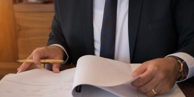 Businessman reviewing documents at desk.