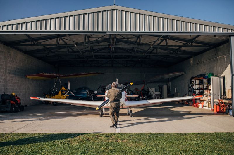 Airplane mechanic repairing propeller airplane in hangar