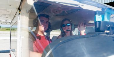 Two people inside a small aircraft cockpit.