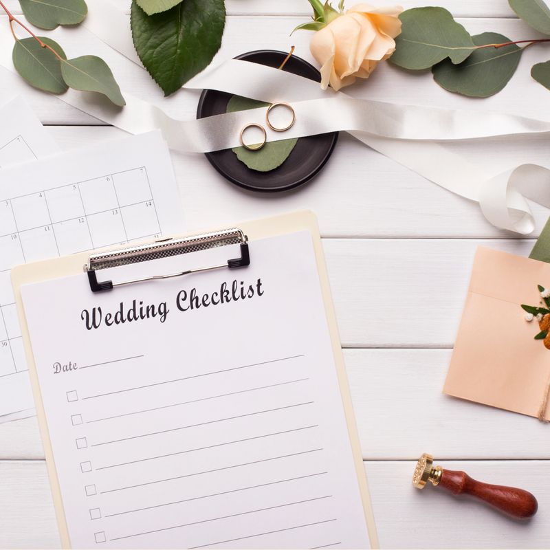 Planning your date. Wedding checklist and accessories on white wooden background