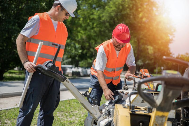 Construction workers using compacting gear at work