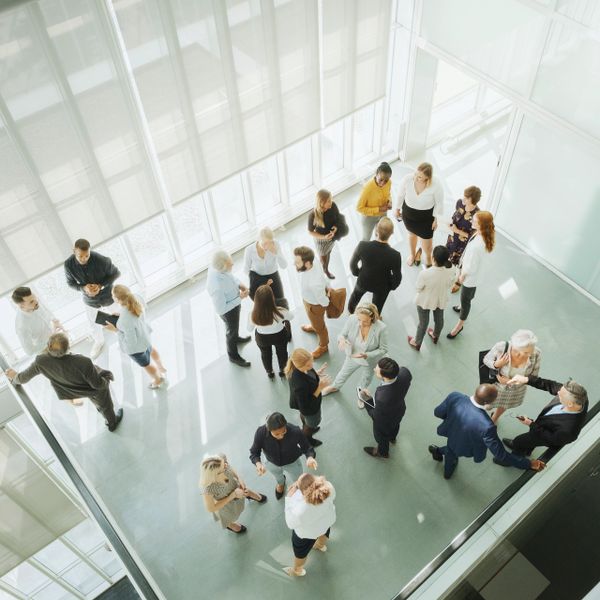 A diverse group of professionals networking in a bright, modern office space.