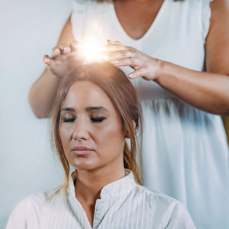 Shamballa Therapist Performing Treatment Holding Hands Over Woman’s Head