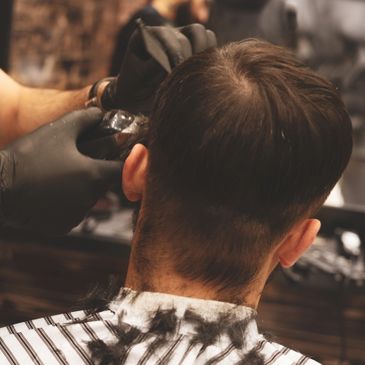 A man getting a haircut at a barber shop.