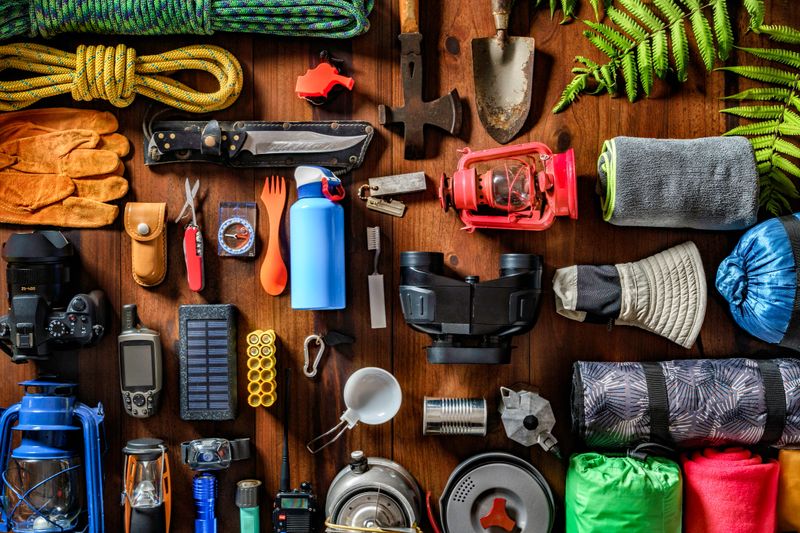 Camping and hiking themes: Top view of large group of gear, equipment and accessories for mountain trips.